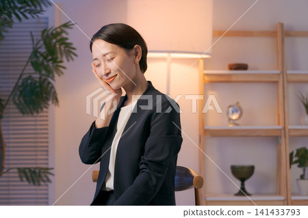 一位身穿西裝的女士正在塗抹護膚品。 一位身穿西裝的女士正在塗抹護膚品。 141433793