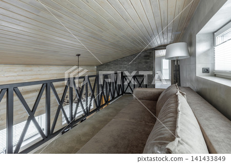 Mezzanine Floor Interior with Sofa, Metal Railing, and Sloped Ceiling Mezzanine Floor Interior with Sofa, Metal Railing, and Sloped Ceiling 141433849
