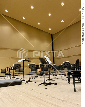 Instruments and music stands lined up on the stage of a concert hall before the performance begins | Music education, concerts, cultural activities, vertical web and social media material 141434516