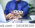 tax icon in wooden block placed on a stack of coins, representing the concepts of taxation, money preservation, economic growth, and future planning. businessman working background. 141436100