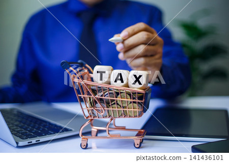 tax icon in wooden block placed on a stack of coins, representing the concepts of taxation, money preservation, economic growth, and future planning. businessman working background. tax icon in wooden block placed on a stack of coins, representing the concepts of taxation, money preservation, economic growth, and future planning. businessman working background. 141436101