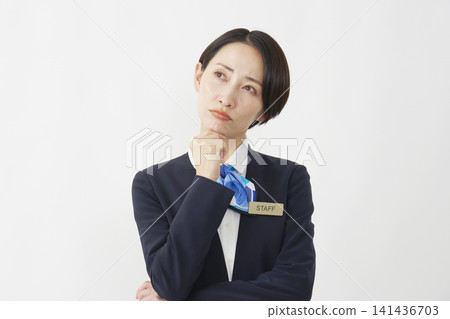 一位四十多歲的女員工在白色背景前思考。 141436703