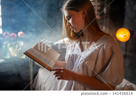 Young female patient reading a book alone in her hospital bed Young female patient reading a book alone in her hospital bed 141436814