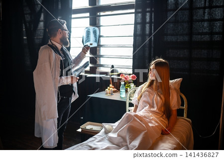 Physician examining chest x-ray scans near a patient 141436827
