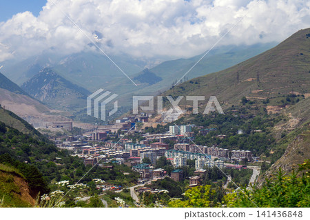 Village in valley surrounded by forested mountains 141436848