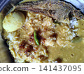 Bengali style khichuri served with fried fish and boiled egg in traditional plate. Bengali style khichuri served with fried fish and boiled egg in traditional plate. 141437095