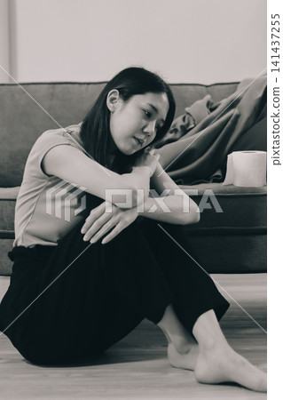 Young Asian woman sitting in bed and holding her head in pain with headache, feeling depressed and suffering Young Asian woman sitting in bed and holding her head in pain with headache, feeling depressed and suffering 141437255