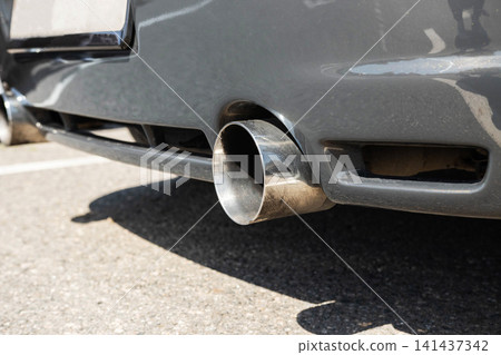 Close-up of chrome exhaust pipe of grey car, rear bumper visible, vehicle detail for car tuning and modern body kits, automotive design element Close-up of chrome exhaust pipe of grey car, rear bumper visible, vehicle detail for car tuning and modern body kits, automotive design element 141437342