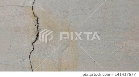 A weathered concrete wall with deep vertical cracks. A weathered concrete wall with deep vertical cracks. 141437677