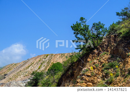 Sunny hillside with rocky slopes and green trees Sunny hillside with rocky slopes and green trees 141437821
