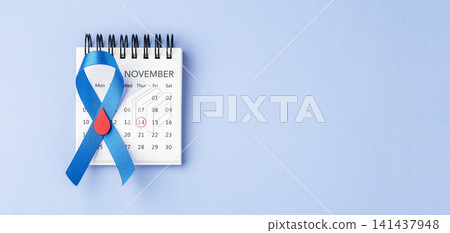 Blue ribbon with a red blood drop on a calendar over a blue background with copy space, World Diabetes Day on November 14 Blue ribbon with a red blood drop on a calendar over a blue background with copy space, World Diabetes Day on November 14 141437948