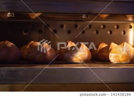"Freshly baked loaves of bread cook inside hot oven, showing golden brown crust and steam, ready for consumption from a bakery factory production line" "Freshly baked loaves of bread cook inside hot oven, showing golden brown crust and steam, ready for consumption from a bakery factory production line" 141438184
