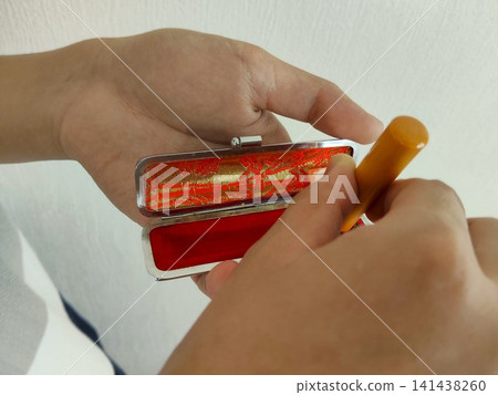 The hand taking the stamp out of the stamp case 141438260