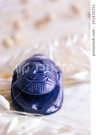 Front view close up of blue lapis lazuli scarab beetle stone carving. Front view close up of blue lapis lazuli scarab beetle stone carving. 141438352