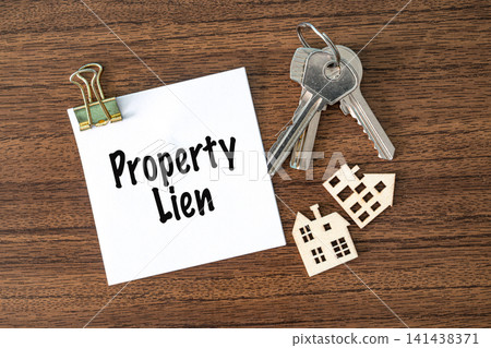 Property Lien text on white paper with keys and toy houses on wooden desk, real estate finance and law concept Property Lien text on white paper with keys and toy houses on wooden desk, real estate finance and law concept 141438371