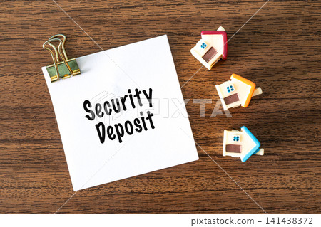 Security Deposit text on white paper with toy houses and binder clips on wooden desk, real estate rental concept Security Deposit text on white paper with toy houses and binder clips on wooden desk, real estate rental concept 141438372