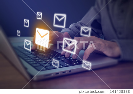 Person typing on laptop with glowing email envelope icons flying, digital communication and email marketing concept 141438388