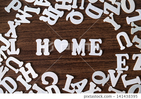 HOME word with heart symbol spelled with letter tiles on scattered letters wooden background, real estate and family concept HOME word with heart symbol spelled with letter tiles on scattered letters wooden background, real estate and family concept 141438395