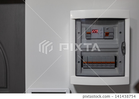 Wall-mounted electrical distribution panel with circuit breakers and protective devices, showing modern residential power management and electrical safety infrastructure indoors Wall-mounted electrical distribution panel with circuit breakers and protective devices, showing modern residential power management and electrical safety infrastructure indoors 141438754