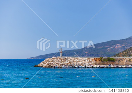 A solitary lighthouse stands on a rocky breakwater, Kalkan, Turkey A solitary lighthouse stands on a rocky breakwater, Kalkan, Turkey 141438830