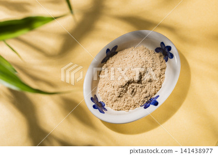 nutritious carob powder on a yellow background, top view 141438977