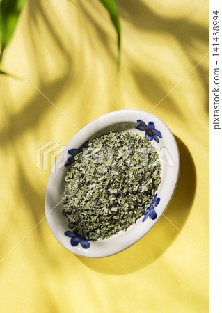 plate with moringa leaves on a yellow background top view plate with moringa leaves on a yellow background top view 141438994