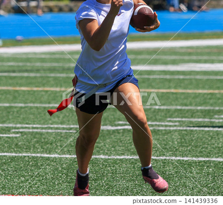 Player Runs With Football on Field During Flag Football Game Player Runs With Football on Field During Flag Football Game 141439336