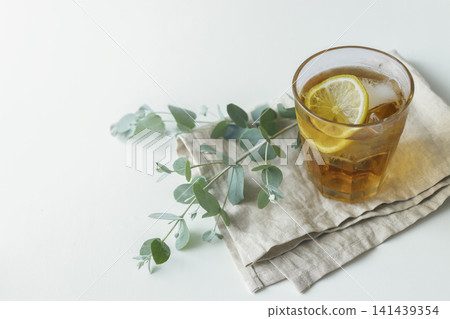 檸檬冰茶和尤加利葉放在亞麻布上——夏日下午茶時光。 檸檬冰茶和尤加利葉放在亞麻布上——夏日下午茶時光。 141439354