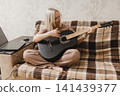 Mature woman learning to play guitar at home 141439377