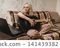 Mature woman learning guitar with a laptop at home 141439382