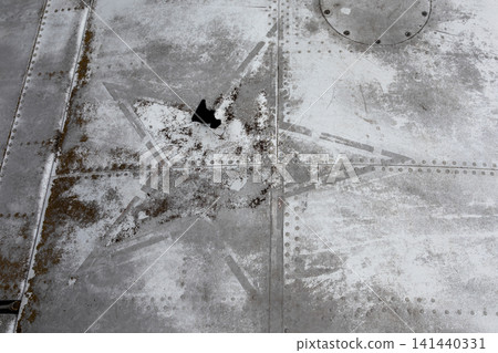 Close-up of grey metal aircraft fuselage with faded star sign marking Close-up of grey metal aircraft fuselage with faded star sign marking 141440331