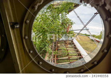 Weathered airplane porthole with broken glass Weathered airplane porthole with broken glass 141440358