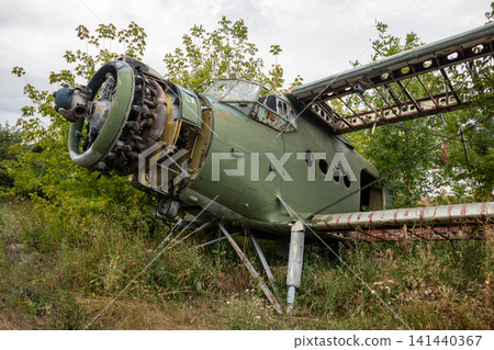 Green Weathered An-2 Airplane in Abandoned Field 141440367