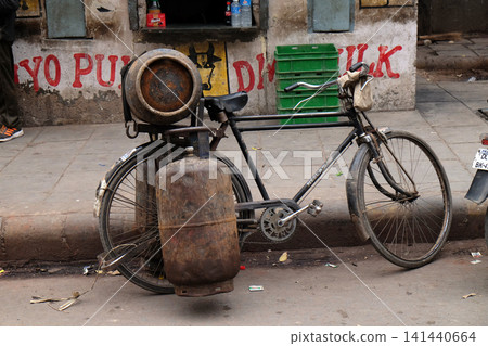 Typical scene of old bike transporting gas bottles to the restaurants in Delhi, India Typical scene of old bike transporting gas bottles to the restaurants in Delhi, India 141440664
