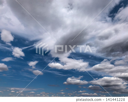 Layered Clouds Stretching Across Bright Blue Summer Sky 141441228