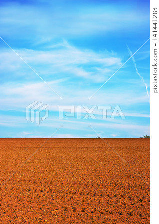 Freshly plowed agricultural field under a lightly clouded sky in the spring time Freshly plowed agricultural field under a lightly clouded sky in the spring time 141441283