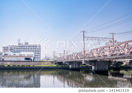 A classic truss bridge spanning a river against a backdrop of a clear blue sky. A classic truss bridge spanning a river against a backdrop of a clear blue sky. 141441519
