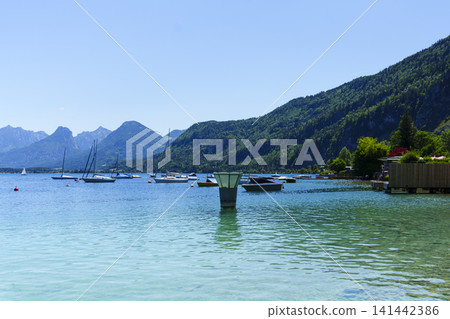 Sailboats on Lake Wolfgangsee in the Salzkammergut, illustrating scenic lake tourism in Austria and classic alpine summer vibe. Sailboats on Lake Wolfgangsee in the Salzkammergut, illustrating scenic lake tourism in Austria and classic alpine summer vibe. 141442386