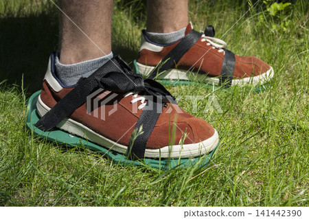 Lawn aerator shoes on grass, illustrating practical garden maintenance for healthy turf and simple manual soil care in home yards. Lawn aerator shoes on grass, illustrating practical garden maintenance for healthy turf and simple manual soil care in home yards. 141442390