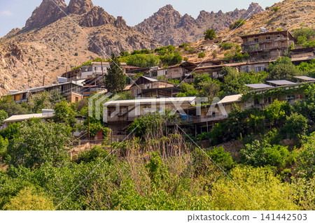 Village clinging to rugged mountain terrain Village clinging to rugged mountain terrain 141442503