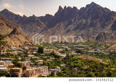 Panoramic view of a village surrounded by jagged mountains Panoramic view of a village surrounded by jagged mountains 141442512