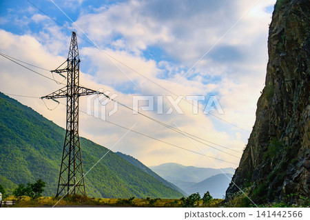 High voltage transmission tower near mountainous terrain High voltage transmission tower near mountainous terrain 141442566