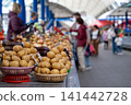 Baskets of potatoes on a stand at a farmers' market or bazaar. Potatoes displayed for sale, grocery store. 141442728