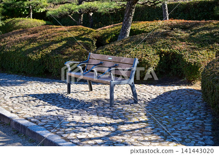 A bench in the public park in Nagoya, Japan. Empty bench in the park in Nagoya. For leisure, relax, resting. A bench in the public park in Nagoya, Japan. Empty bench in the park in Nagoya. For leisure, relax, resting. 141443020