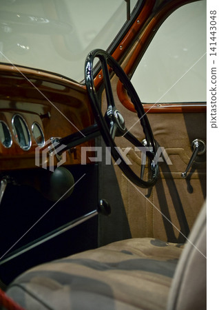 Detail of the interior of a vintage car. Retro car. Close-up of the old steering wheel, console, seats, insides of the retro car. Interior of a classic vintage car Detail of the interior of a vintage car. Retro car. Close-up of the old steering wheel, console, seats, insides of the retro car. Interior of a classic vintage car 141443048