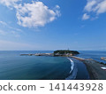 A photo taken from a high vantage point at Katase Higashihama Beach, showing Enoshima Island surrounded by the sea and the sandy beach. 141443928
