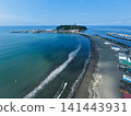 A photo taken from a high vantage point at Katase Higashihama Beach, showing Enoshima Island surrounded by the sea and the sandy beach. 141443931