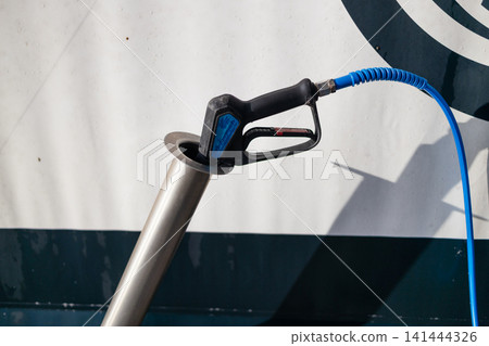 Pressure washer spray nozzle injector placed in socket at carwash station. Pressure washer spray nozzle injector placed in socket at carwash station. 141444326