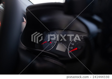 Dashboard console panel of a vehicle driving at night. Car interior details, speed dial display. Dashboard console panel of a vehicle driving at night. Car interior details, speed dial display. 141444330