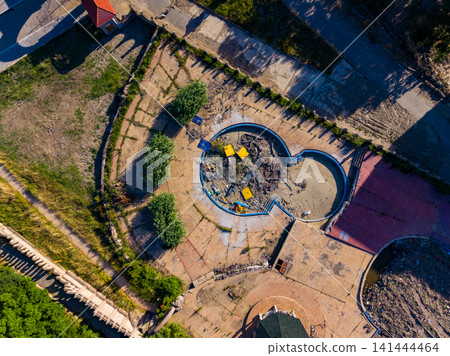 Elenite city shows damage and debris after flood, revealing empty pool and surrounding area with rubble Elenite city shows damage and debris after flood, revealing empty pool and surrounding area with rubble 141444464